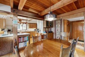 a dining room with a wooden table and a kitchen at Schooner in Sea Ranch