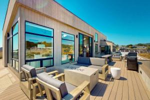 a patio with a couch and chairs on a deck at Cabañita Del Mar in Sea Ranch