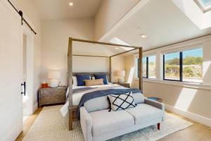 a bedroom with a bed and a couch and windows at Cabañita Del Mar in Sea Ranch