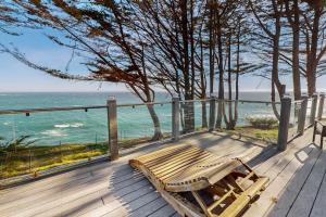 a wooden bench sitting on a deck overlooking the ocean at Oceanfront Dream Hideaway and Retreat in Gualala