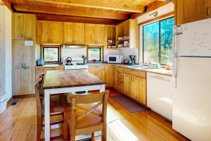 a kitchen with wooden cabinets and a white refrigerator at Ocean Pines Lodge in Sea Ranch