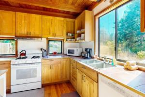 a kitchen with wooden cabinets and a large window at Ocean Pines Lodge in Sea Ranch +22 photos