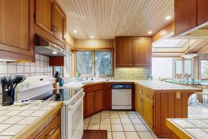 a large kitchen with wooden cabinets and white appliances at Cypress Cove in Sea Ranch +33 photos