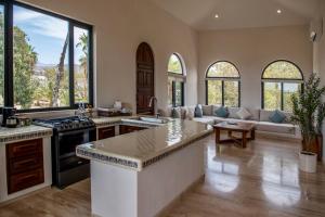 a kitchen and living room with a couch and a table at Hacienda Todos Los Santos in Todos Santos