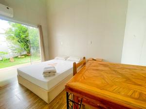 a bedroom with a bed and a large window at Wafeh Fleming Suítes Pampulha in Belo Horizonte