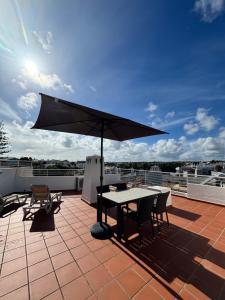 a patio with a table and an umbrella on a roof at Casa Julio-Rooftop Terrace & Pool 5 Min to Beach in Carvoeiro +26 photos