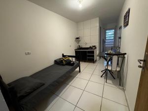 a room with a bed and a desk in it at SJ Suites in São José dos Pinhais