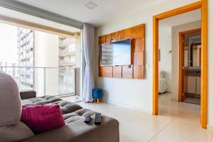 a living room with a couch and a large window at AP Df Plaza varandão in Brasília
