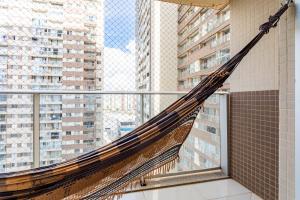 a hammock in a balcony with tall buildings at AP Df Plaza varandão in Brasília