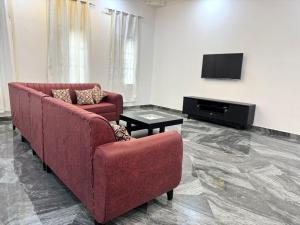 a living room with two red couches and a tv at Casa del Zanzibar in Zanzibar City