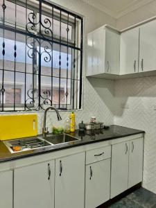 a kitchen with white cabinets and a sink and a window at Casa del Zanzibar in Zanzibar City +5 photos