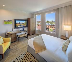 pokój hotelowy z dużym łóżkiem i telewizorem w obiekcie Hotel E w mieście Santa Rosa
