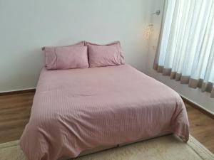 a pink bed with pink pillows in a bedroom at loft B in Fez