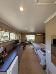 a bedroom with two beds and a desk with a television at Motel Strahan in Strahan