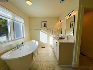 a bathroom with a large white tub and a sink at Morning Dew105 in Hammonds Plains +49 photos