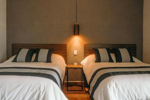 a bedroom with two beds and a pendant light at El Mesón de Don José in La Mesa +5 photos