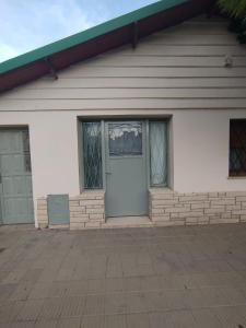 a white house with a door and two windows at Jujuy 555 Nqn in Neuquén