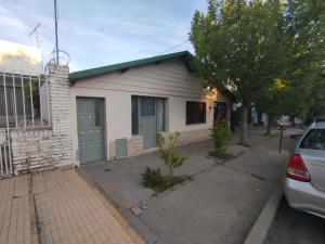 a white house with a car parked in front of it at Jujuy 555 Nqn in Neuquén