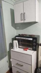 a microwave on top of a cabinet in a kitchen at Jujuy 555 Nqn in Neuquén