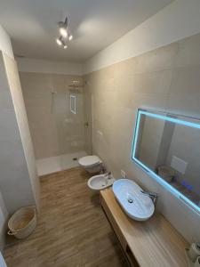 a bathroom with two toilets and a sink and a mirror at SUITE LUX apulia in Massafra