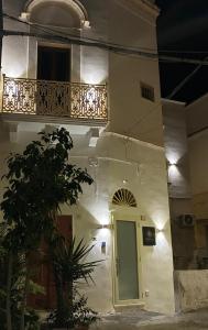 a white building with a balcony and a door at SUITE LUX apulia in Massafra