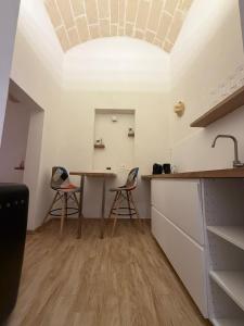 a kitchen with a table and chairs in a room at SUITE LUX apulia in Massafra