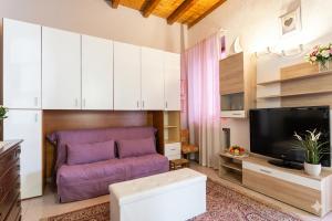 a living room with a purple couch and a tv at a casa di Max in Trezzo sullʼAdda