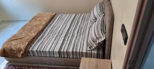 a small bed in a room with a wooden box at Tata hôte in Tatta