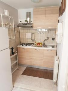 a small kitchen with wooden cabinets and a sink at a casa di Max in Trezzo sullʼAdda +11 photos