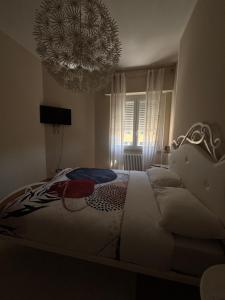 a bedroom with a large bed and a chandelier at The Green Nest Perugia in Perugia
