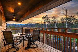 a patio with a table and chairs on a deck at Firefly Cabin in Pigeon Forge