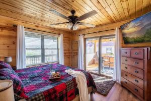 a bedroom with a bed and a ceiling fan at Firefly Cabin in Pigeon Forge
