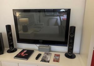 a television sitting on top of a table with speakers at Luxury House Cascais in Cascais