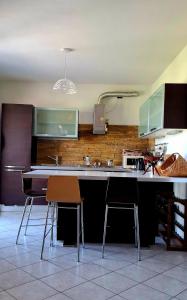 a kitchen with a counter and two chairs in it at La finestra sul lago in Clusane sul Lago +11 photos