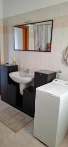 a bathroom with a sink and a toilet and a mirror at La finestra sul lago in Clusane sul Lago