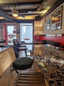 a restaurant with chairs and a bar with a counter at Hôtel de la Gare - Morlaix in Morlaix