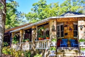 a stone house with blue chairs on the porch at Cabin Hilltop D on Meramec River in Steelville