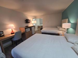 a hotel room with two beds and a desk at Howard Johnson by Wyndham Hinton in Hinton