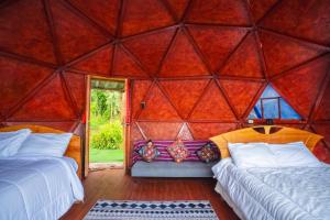 a room with two beds and a room with a window at Antawara Gampling in Yaulloc