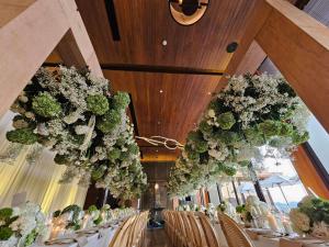 a dining room with tables and chairs with flowers at V Villas Phuket - MGallery Collection in Panwa Beach +153 photos