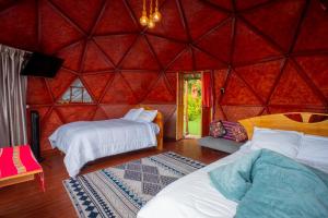 a room with two beds in a red tent at Antawara Gampling in Yaulloc