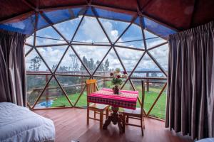 a room with a large window with a table in it at Antawara Gampling in Yaulloc +5 photos