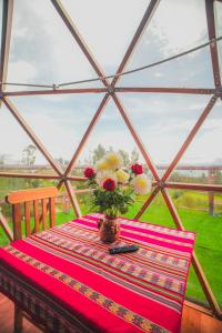 a table with a vase of flowers on top of a tent at Antawara Gampling in Yaulloc