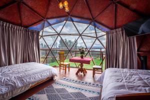 a room with two beds and a table in a igloo at Antawara Gampling in Yaulloc