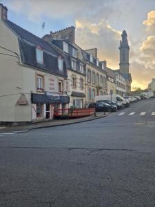 a city street with buildings and a clock tower at Hôtel de la Gare - Morlaix in Morlaix