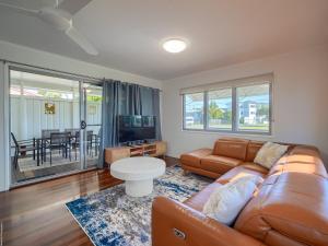 a living room with a couch and a table at Ocean Getaway in Hervey Bay