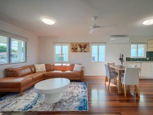 a living room with a couch and a table at Ocean Getaway in Hervey Bay