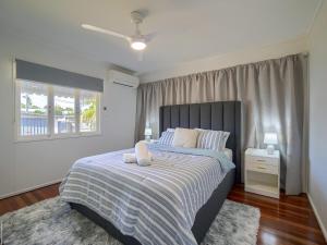 a bedroom with a large bed and a window at Ocean Getaway in Hervey Bay