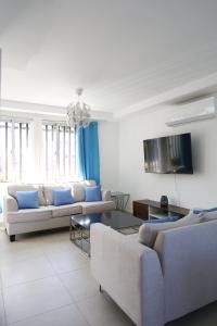 a living room with two couches and a tv at Villa Labuena in Punta Cana