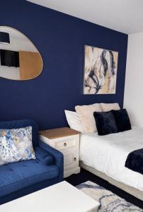 a bedroom with a bed and a blue wall at Hotel Style Room within Reading in Reading